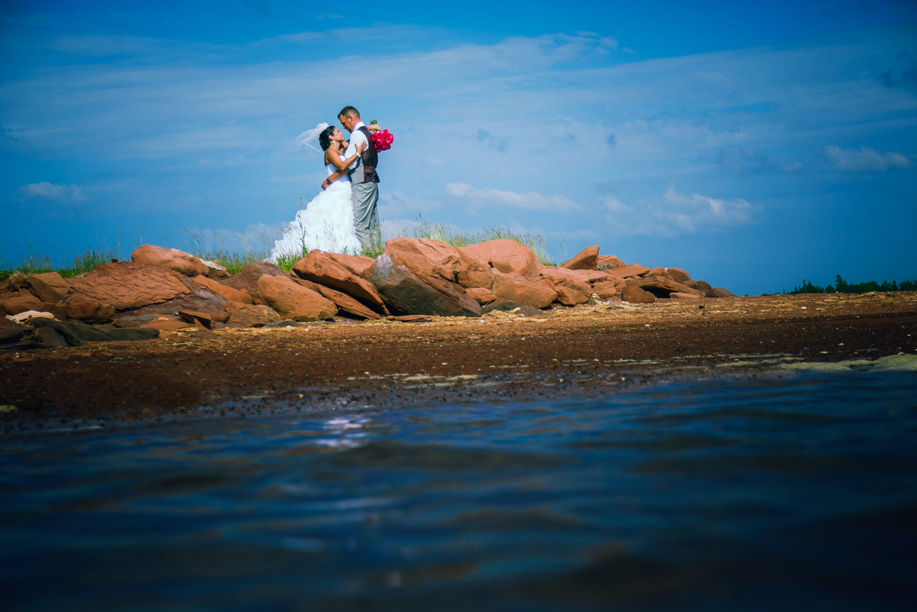 A couple embrace on the beach during their wedding at Rodd Brudenell River Resort.